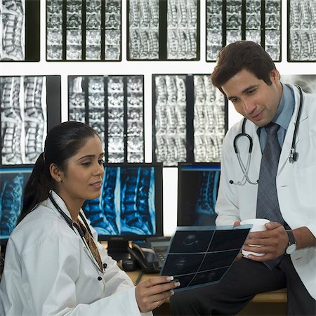 simsearch:630-03480765,k - Female doctor with a male doctor examining an X-Ray report Foto de stock - Sin royalties Premium, Código: 630-03480761