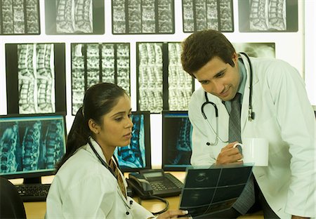 Female doctor with a male doctor examining an X-Ray report Stock Photo - Premium Royalty-Free, Code: 630-03480763