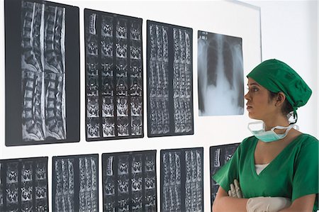 simsearch:630-03480828,k - Female surgeon examining an X-Ray report Foto de stock - Sin royalties Premium, Código: 630-03480835