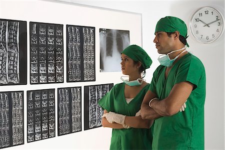 simsearch:630-03480964,k - Female surgeon with a male surgeon examining an X-Ray report Foto de stock - Sin royalties Premium, Código: 630-03480838