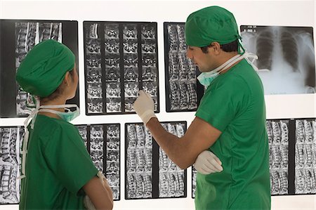 Female surgeon with a male surgeon examining an X-Ray report Stock Photo - Premium Royalty-Free, Code: 630-03480842