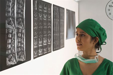 simsearch:630-03480856,k - Female surgeon examining an X-Ray report Stock Photo - Premium Royalty-Free, Code: 630-03480850