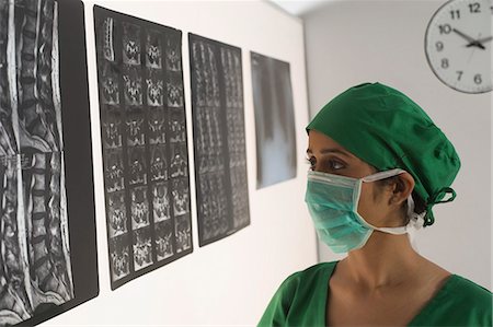 simsearch:630-03480828,k - Female surgeon examining an X-Ray report Foto de stock - Sin royalties Premium, Código: 630-03480851