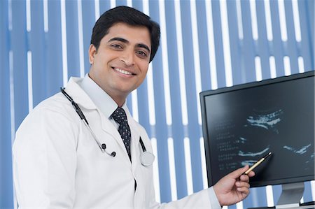 Male doctor examining ultrasound and smiling Foto de stock - Sin royalties Premium, Código: 630-03480862