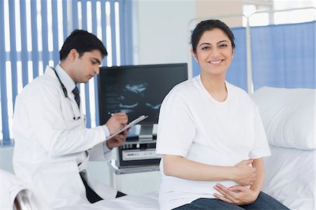 female body front view - Female patient smiling with a male doctor writing a prescription Stock Photo - Premium Royalty-Free, Code: 630-03480874