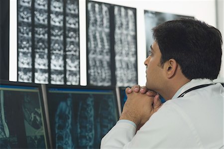 doctor looking at xray - Male doctor examining X-Ray report Stock Photo - Premium Royalty-Free, Code: 630-03480885