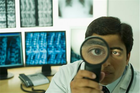 simsearch:630-03481013,k - Male doctor holding a magnifying glass Foto de stock - Sin royalties Premium, Código: 630-03480903