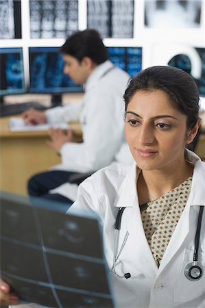 doctor looking at xray - Female doctor examining X-Ray report Stock Photo - Premium Royalty-Free, Code: 630-03480946