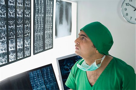 Male doctor examining X-Ray report Foto de stock - Sin royalties Premium, Código: 630-03481018