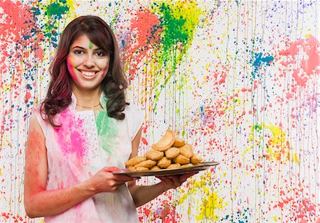 Woman holding a plate of gujia and smiling Stock Photo - Premium Royalty-Free, Code: 630-03481068