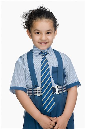 Portrait of a schoolgirl wearing school uniform and smiling Stock Photo - Premium Royalty-Free, Code: 630-03481139