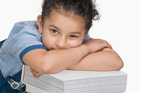 Schoolgirl leaning on a stack of books Stock Photo - Premium Royalty-Free, Code: 630-03481174