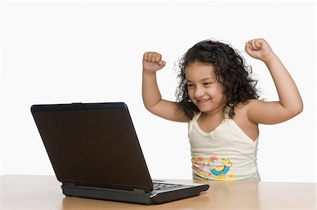 simsearch:630-03481209,k - Girl cheering in front of a laptop Fotografie stock - Premium Royalty-Free, Codice: 630-03481184