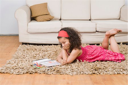 Girl lying with a notebook and colored pencils Stock Photo - Premium Royalty-Free, Code: 630-03481209