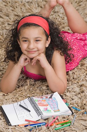 Girl lying with a notebook and colored pencils Stock Photo - Premium Royalty-Free, Code: 630-03481213