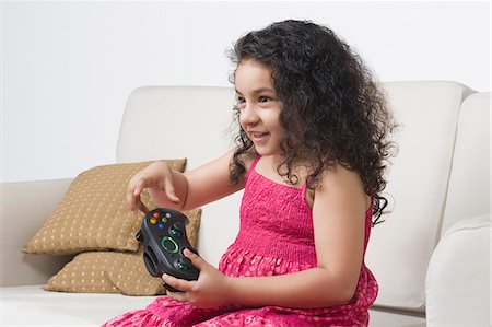 simsearch:632-05760667,k - Girl playing a video game and smiling Foto de stock - Royalty Free Premium, Número: 630-03481224