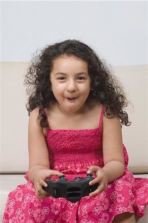 simsearch:630-03481209,k - Girl playing a video game and making a funny face Fotografie stock - Premium Royalty-Free, Codice: 630-03481220