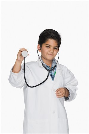 Boy imitating a doctor and holding a stethoscope Foto de stock - Sin royalties Premium, Código: 630-03481247