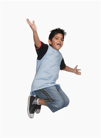 profile of boy jumping - Boy jumping in air with his arm outstretched Stock Photo - Premium Royalty-Free, Code: 630-03481262
