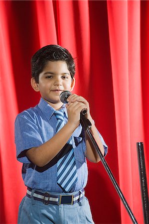 people singing on stage - Schoolboy singing into a microphone on a stage Stock Photo - Premium Royalty-Free, Code: 630-03481296