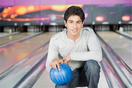 simsearch:630-03481667,k - Young man holding a bowling ball in a bowling alley Foto de stock - Royalty Free Premium, Número: 630-03481537