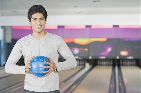 simsearch:630-03481667,k - Young man holding a bowling ball in a bowling alley Foto de stock - Royalty Free Premium, Número: 630-03481544
