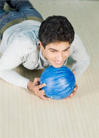 simsearch:630-03481638,k - Jeune homme couché avec une boule de bowling dans une ruelle de bowling Photographie de stock - Premium Libres de Droits, Code: 630-03481547