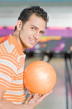 simsearch:630-03481667,k - Young man holding a bowling ball in a bowling alley Foto de stock - Royalty Free Premium, Número: 630-03481555