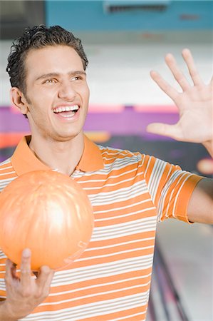 simsearch:630-03481611,k - Young man holding a bowling ball and gesturing in a bowling alley Stock Photo - Premium Royalty-Free, Code: 630-03481556