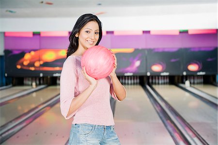 simsearch:630-03481602,k - Jeune femme tenant une boule de bowling dans une allée de quilles Photographie de stock - Premium Libres de Droits, Code: 630-03481567