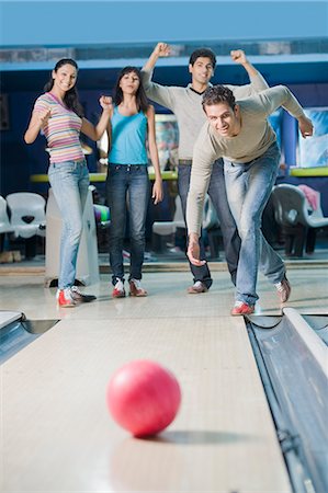 simsearch:630-03481611,k - Young man bowling in a bowling alley and his friends watching him Stock Photo - Premium Royalty-Free, Code: 630-03481600