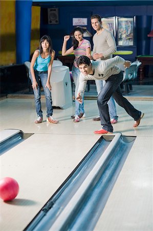 simsearch:693-06015216,k - Young man bowling in a bowling alley and his friends watching him Stock Photo - Premium Royalty-Free, Code: 630-03481603