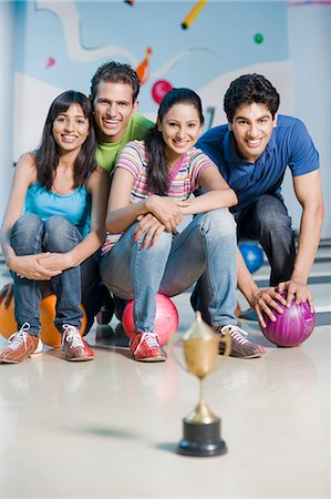 solid - Two young couples with bowling balls and a trophy in a bowling alley Stock Photo - Premium Royalty-Free, Code: 630-03481612