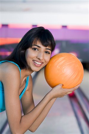 simsearch:630-03481638,k - Jeune femme tenant une boule de bowling dans une allée de quilles Photographie de stock - Premium Libres de Droits, Code: 630-03481629