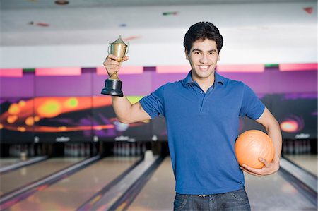 simsearch:630-03481611,k - Young man holding a bowling ball in a bowling alley Stock Photo - Premium Royalty-Free, Code: 630-03481621