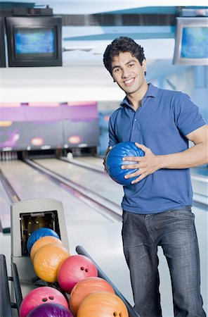 simsearch:630-03481667,k - Young man holding a bowling ball in a bowling alley Foto de stock - Royalty Free Premium, Número: 630-03481660
