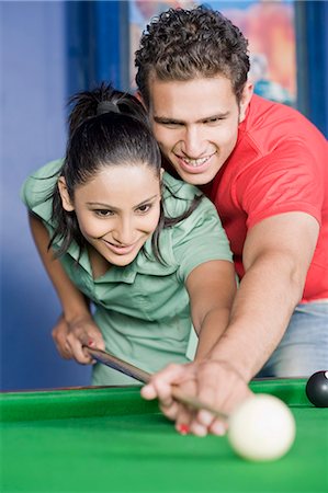 pool cue - Young man teaching pool to a young woman Stock Photo - Premium Royalty-Free, Code: 630-03481689