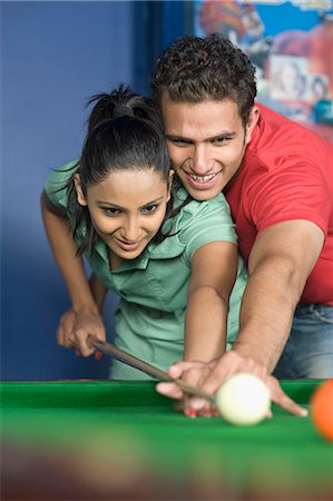 Young man teaching pool to a young woman Stock Photo - Premium Royalty-Free, Code: 630-03481690