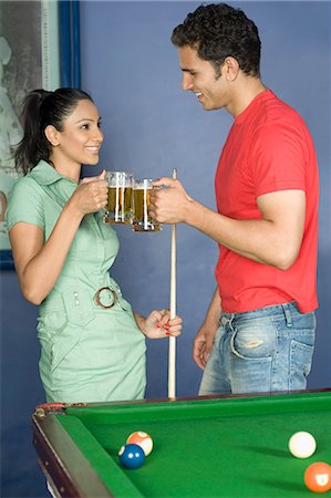 Young couple toasting beer glasses in the pool room Stock Photo - Premium Royalty-Free, Code: 630-03481691