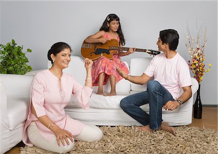 Girl playing guitar with her parents Stock Photo - Premium Royalty-Free, Code: 630-03482014