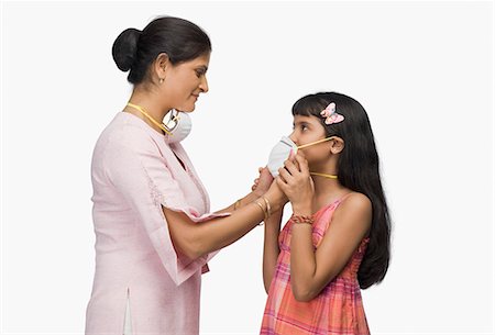 east indian mother and children - Young woman putting a pollution mask to her daughter Stock Photo - Premium Royalty-Free, Code: 630-03482018