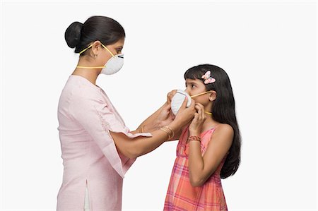 Jeune femme mettre un masque de la pollution à sa fille Photographie de stock - Premium Libres de Droits, Code: 630-03482019