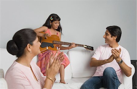 Girl playing a guitar and her parents applauding Foto de stock - Sin royalties Premium, Código: 630-03482011