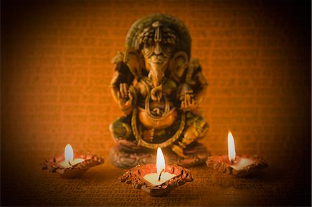 Diwali oil lamps in front of an idol of Lord Ganesha Stock Photo - Premium Royalty-Free, Code: 630-03482042