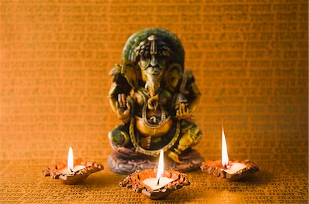 diwali lights photography - Diwali oil lamps in front of an idol of Lord Ganesha Stock Photo - Premium Royalty-Free, Code: 630-03482043