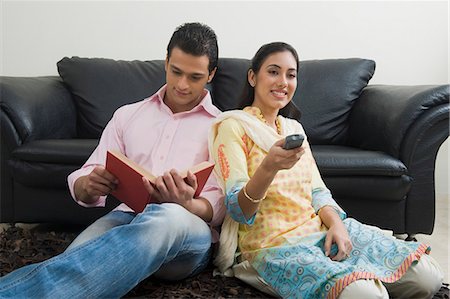 entertain at home - Man reading a book while his wife watching television Stock Photo - Premium Royalty-Free, Code: 630-03482637