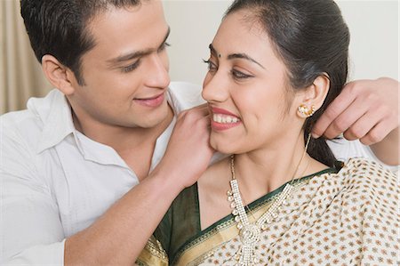 Man putting a necklace on a woman's neck Stock Photo - Premium Royalty-Free, Code: 630-03482667