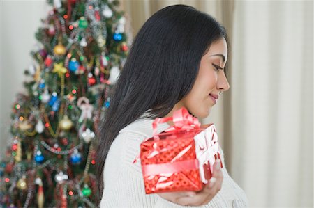 simsearch:630-03482729,k - Woman holding a Christmas present Foto de stock - Royalty Free Premium, Número: 630-03482714
