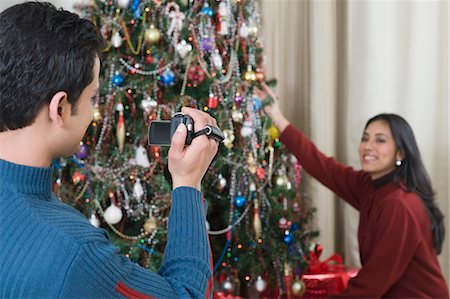 simsearch:630-03482746,k - Man filming his wife decorating Christmas tree Stock Photo - Premium Royalty-Free, Code: 630-03482739