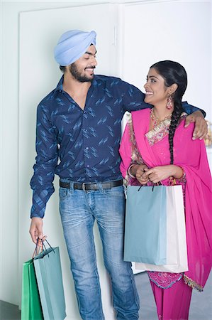 simsearch:630-03482799,k - Couple carrying shopping bags and smiling Stock Photo - Premium Royalty-Free, Code: 630-03482875